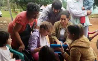 Maria showing children in Paraguay assistive technology